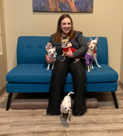 Makyla sitting with 5 small dogs